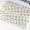 White prototyping breadboard with 30 tie strips and two power rails on each side.